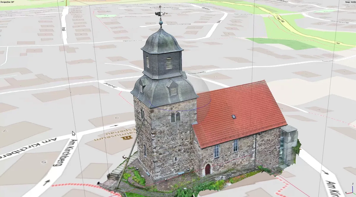 Texturiertes 3D-Modell einer Dorfkirche mit Bruchsteinturm, geschieferter Haube und rotem Ziegeldach über dem Ortsplan